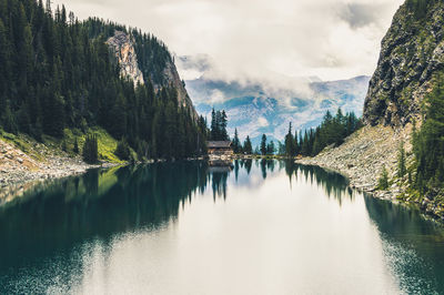 Scenic view of river and rocky mountains against clear sky