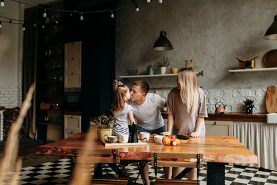 A happy cheerful family with a child is cooking dinner together in the kitchen at home