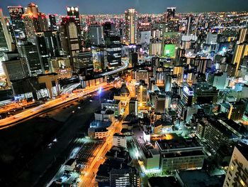 High angle view of illuminated street amidst buildings in city