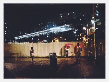 People in illuminated city at night