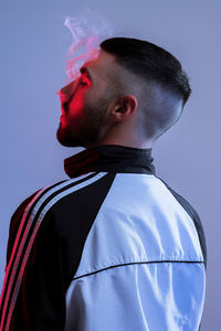 Portrait of young man standing against blue background