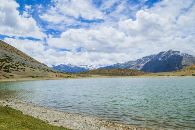 Scenic view of lake by mountains against sky