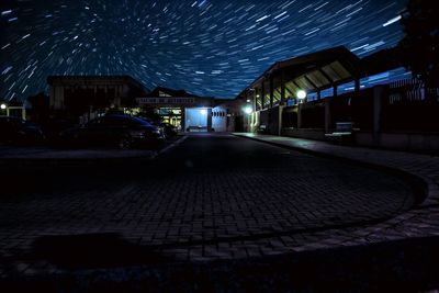 Illuminated street amidst buildings at night