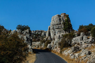 Scenic view of cliff against clear blue sky