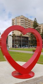 Close-up of red structure against sky in city