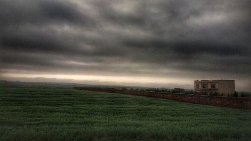 Scenic view of field against cloudy sky