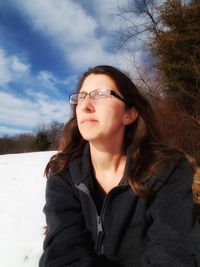 Portrait of young woman against sky