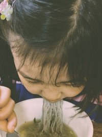 High angle view of girl eating noodles