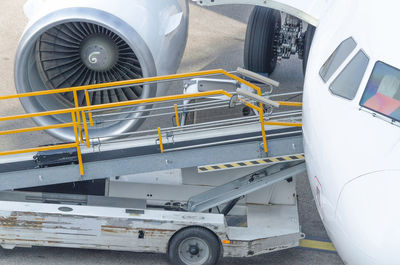 High angle view of passenger boarding bridge by airplane at airport