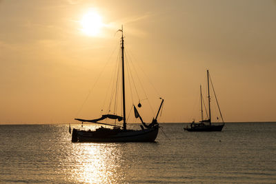 Sailboat sailing on sea against sky during sunset