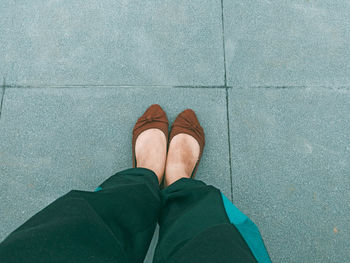 Low section of woman standing on footpath