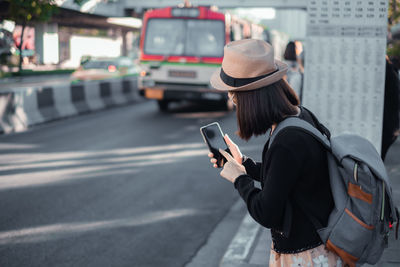 Man using mobile phone on street in city