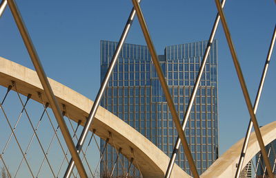 Low angle view of suspension bridge against clear blue sky