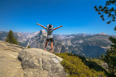 Full length of man standing on rock against sky