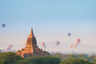 Hot air balloons in temple against clear sky