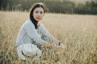 Mid adult woman relaxing on grassy field