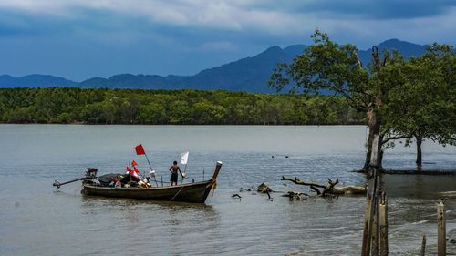 People in boat on river against sky