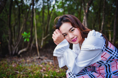 Portrait of a smiling young woman in forest