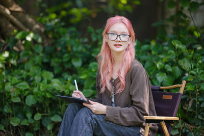 Portrait of young woman sitting on chair