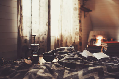 Coffee pot and cup on bed at home