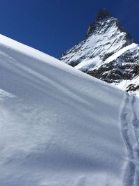 Scenic view of snow covered mountains against clear sky