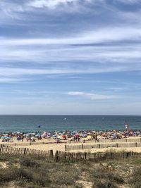 Group of people on beach against sky