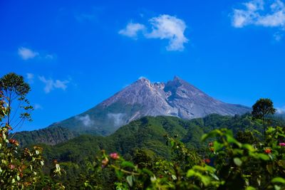 Scenic view of mountains against blue sky