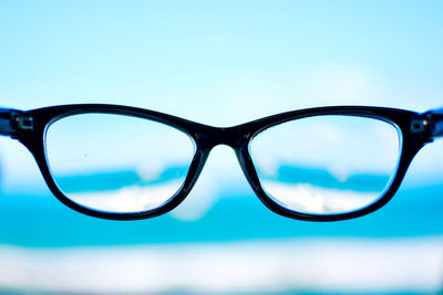 Close-up of sunglasses against sky