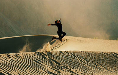 Full length of man jumping at desert