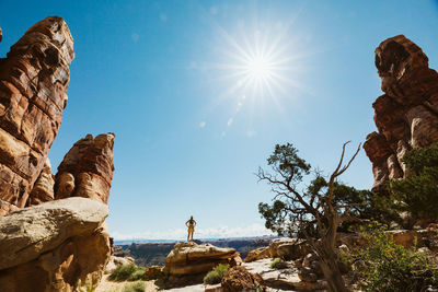 Woman hiker with hands on hips looks at the view in the maze utah