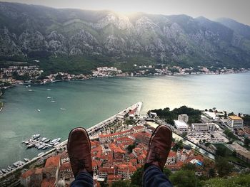 Low section of person over city against mountain