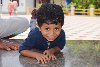 Portrait of smiling boy sitting outdoors