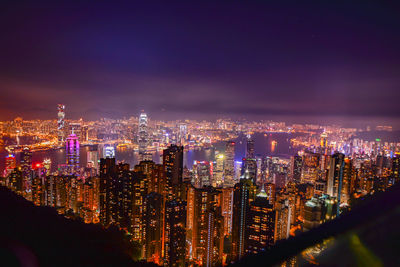 Illuminated cityscape against sky at night