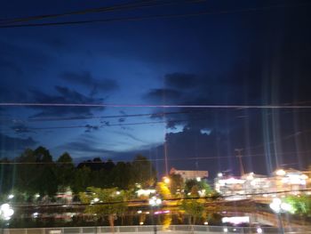 Illuminated buildings in city against sky at night
