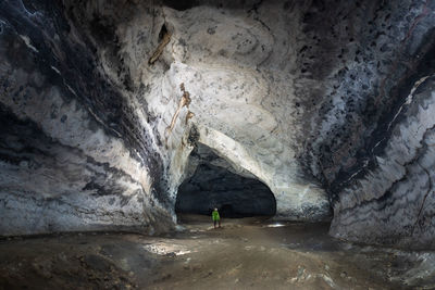 Rear view of man standing in cave