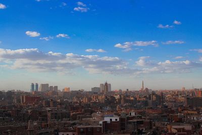 Aerial view of buildings in city against sky