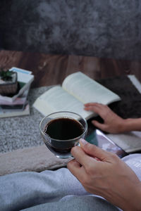 Midsection of woman holding coffee cup