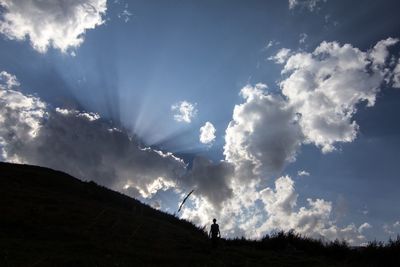 Low angle view of landscape against cloudy sky