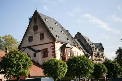 Low angle view of trees and buildings against sky