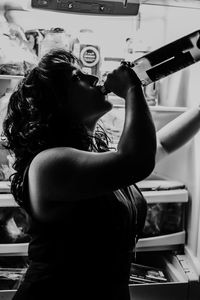 Woman drinking water while standing at home