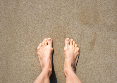 Low section of man legs on sand