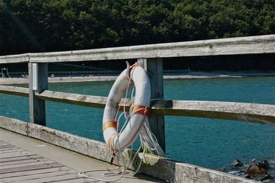 Man standing on railing by sea