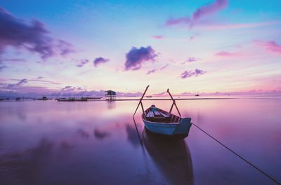 Boat in sea against sky during sunset