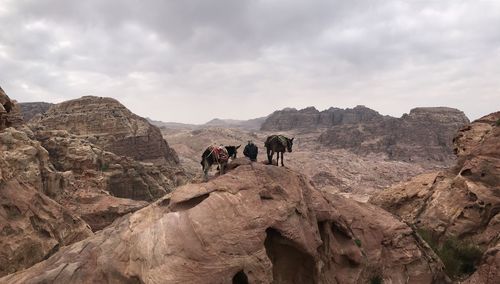 Group of people on rock formation against sky in the desert of giordania 