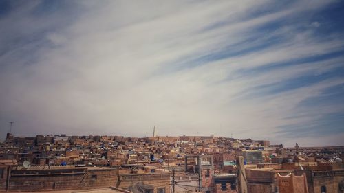 Cityscape against cloudy sky