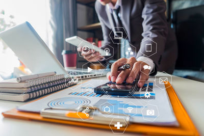 Midsection of man using laptop on table