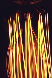 Close-up of illuminated light bulbs against black background