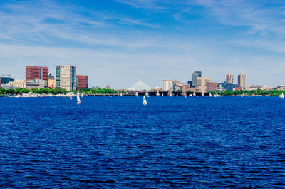 Sea and cityscape against blue sky