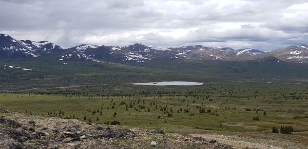 Scenic view of field and mountains against sky