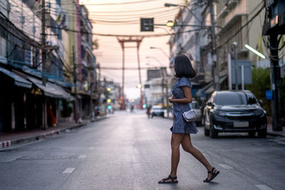 Rear view of woman walking on city street